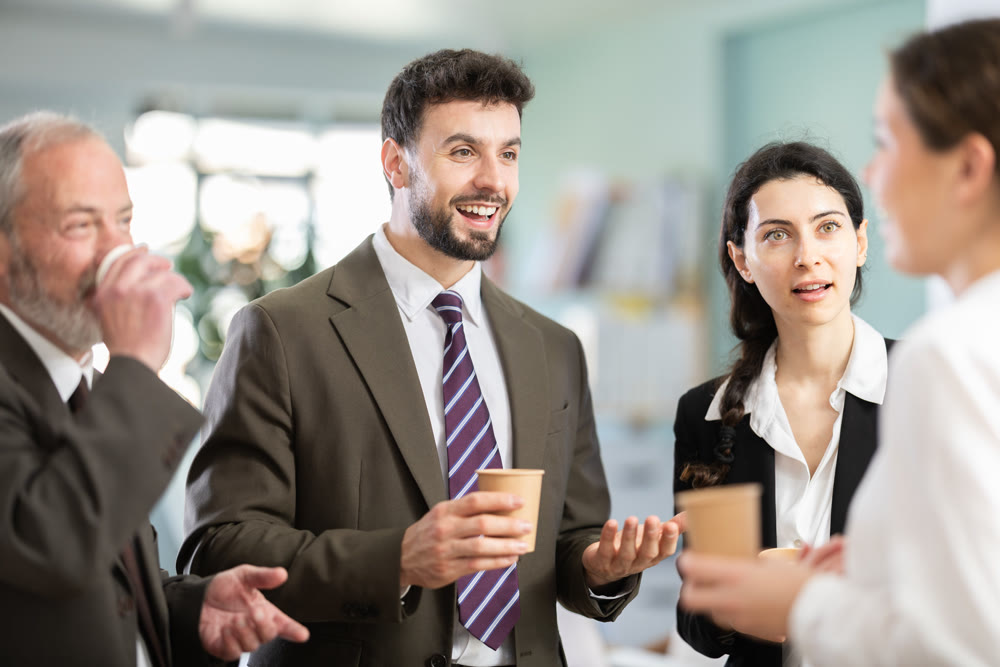 Multiage colleagues chat and laugh during coffee break