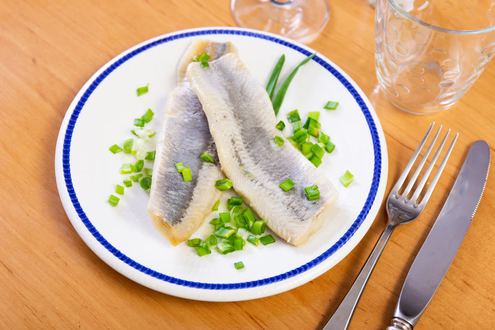 Herring slices served with onions on platter