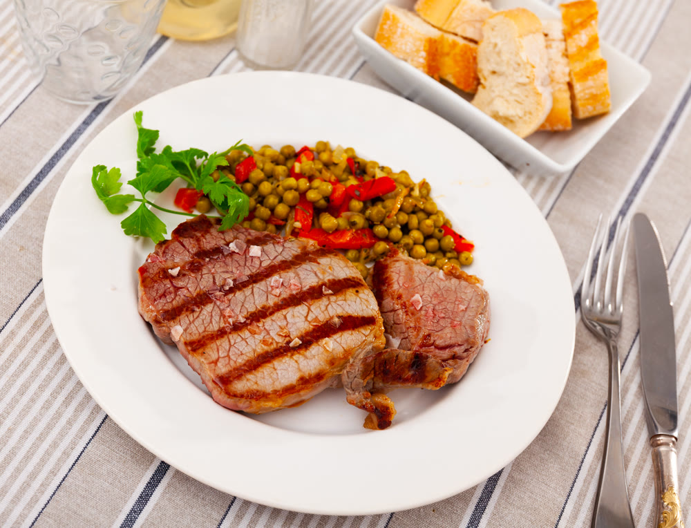 Fried beef served with peas and peppers