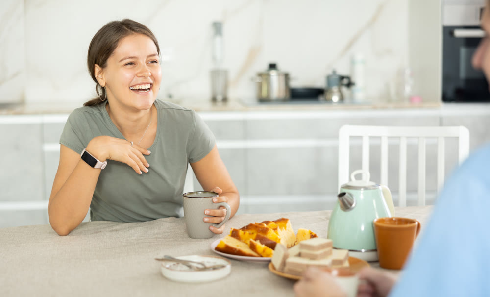 Woman visited female friend and is chatting sweetly and drinking coffee tea.