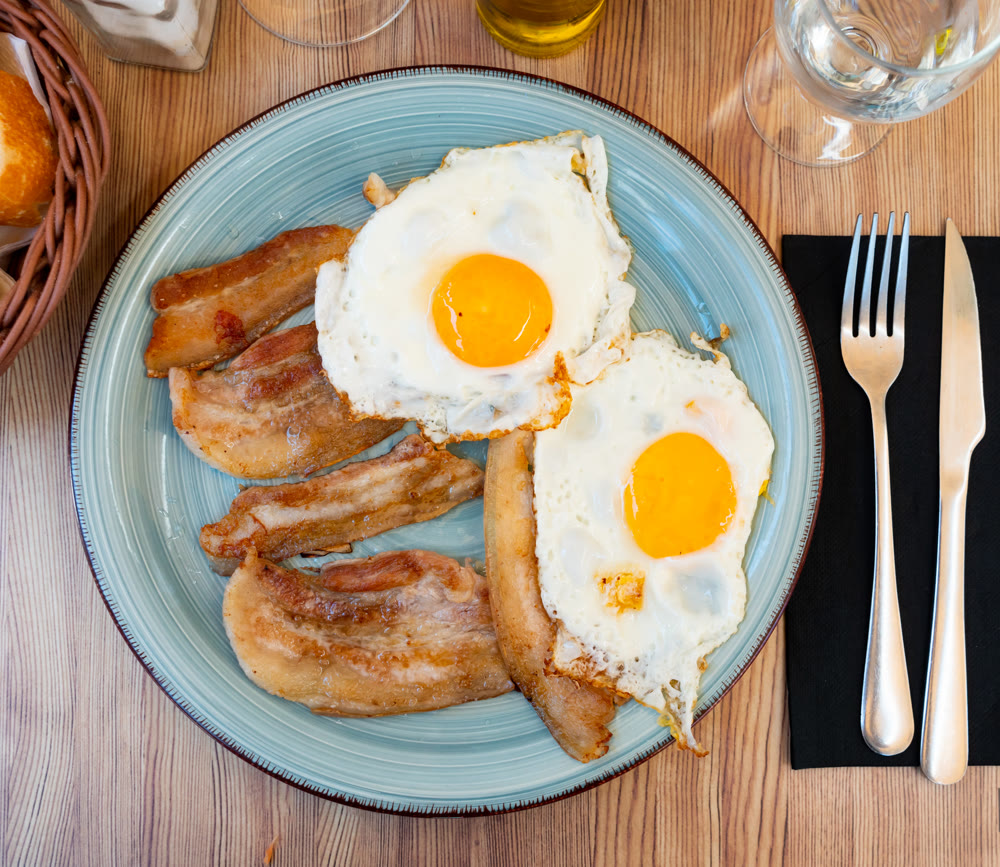 Fried sunny side up eggs with crispy pancetta slices