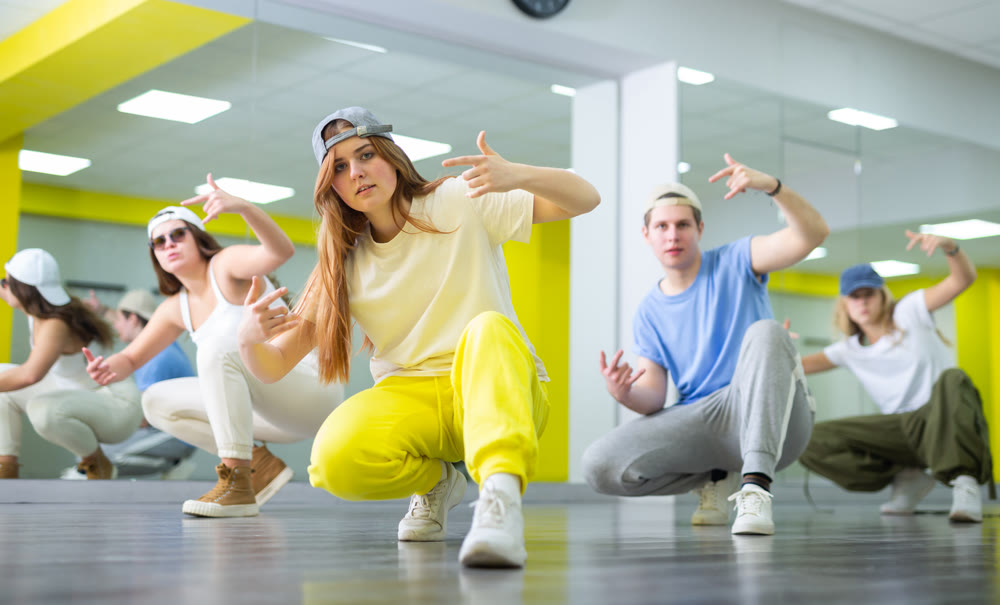 Teen girl in cap dances hip hop dances