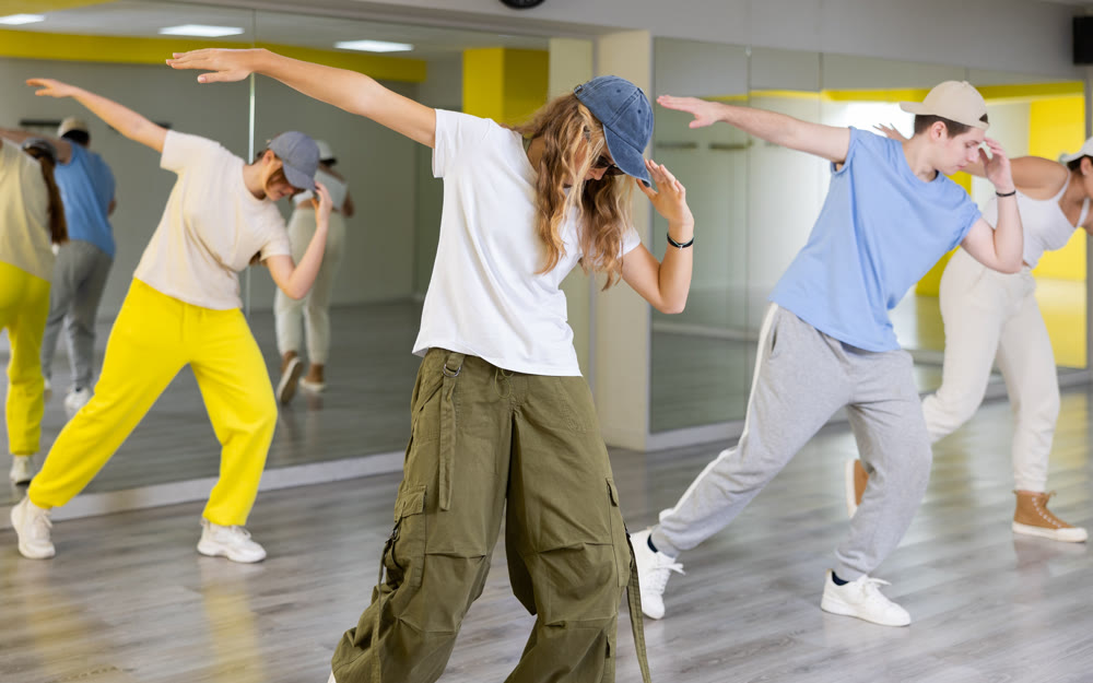 Teen girl in cap dancing modern dances