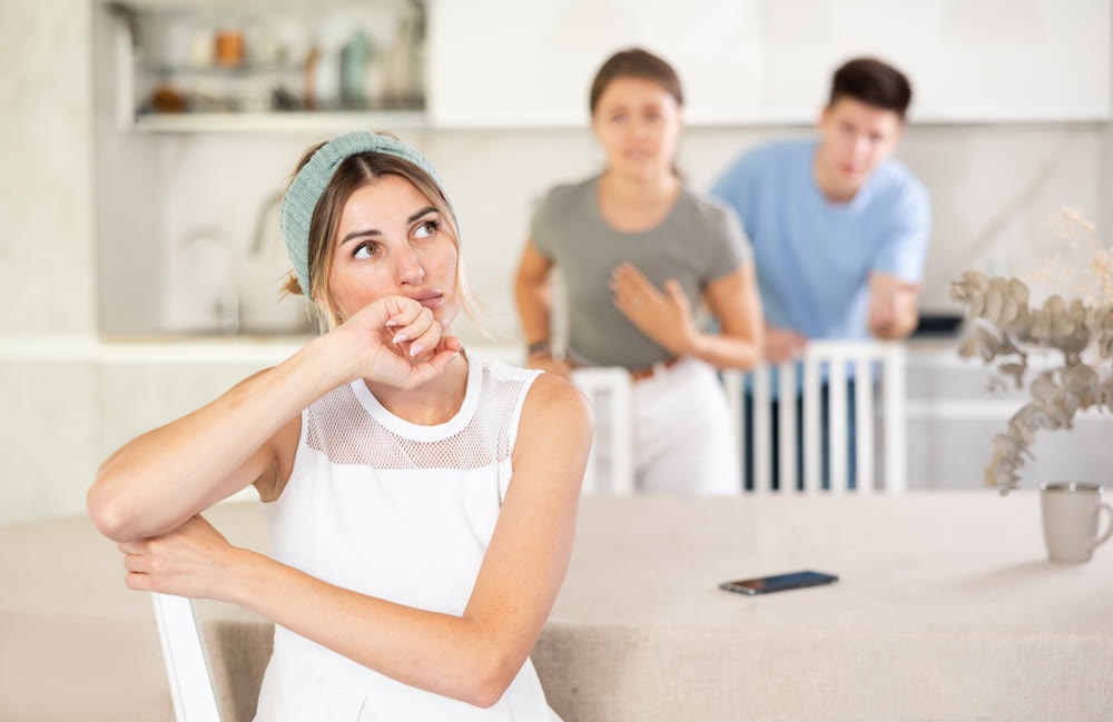 An offended woman tolerates screaming children at home in kitchen