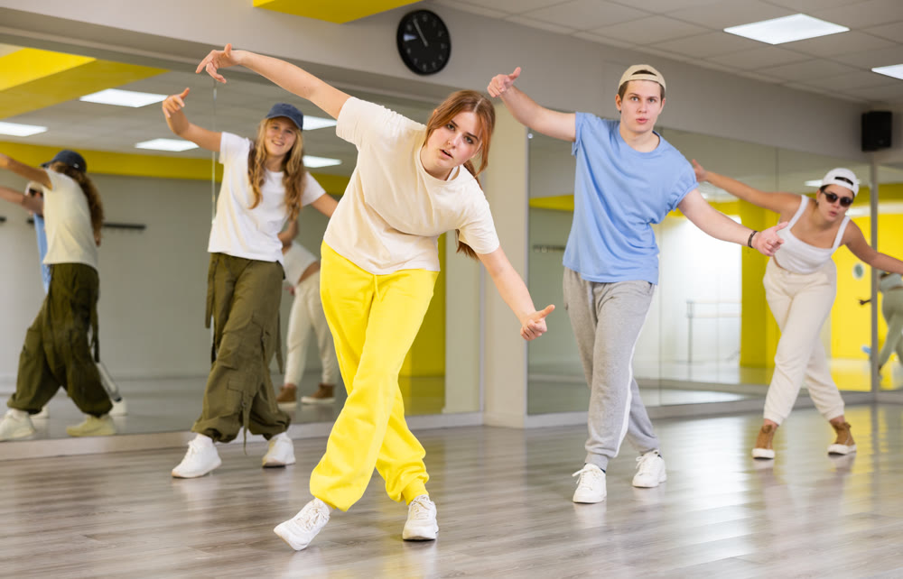 Expressive cool young dancers rehearsing their new dance during training together in studio