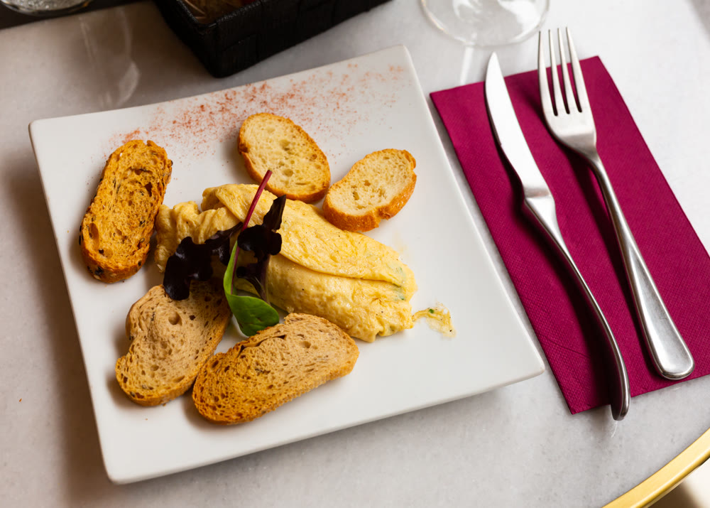 Tasty and nutritious omelette served with crispy toast decorated with herbs