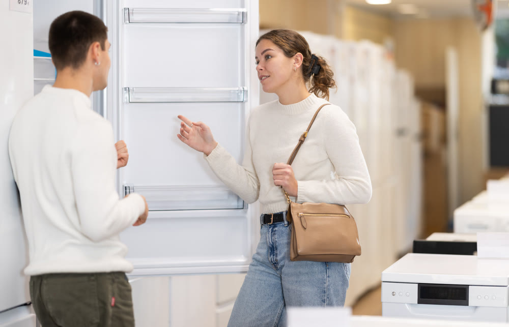 Couple choosing a refrigerator in an equipment store