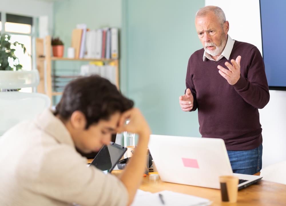Mature male manager is dissatisfied with the work of an employee - yells and reproaches her