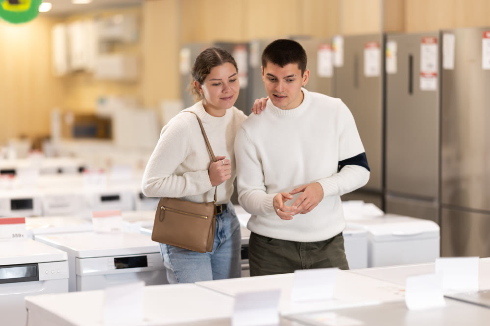 Couple customer inspect product range and selects dishwashing machine or washing machine