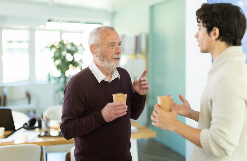 Male colleagues drink coffee and have nice conversation during break
