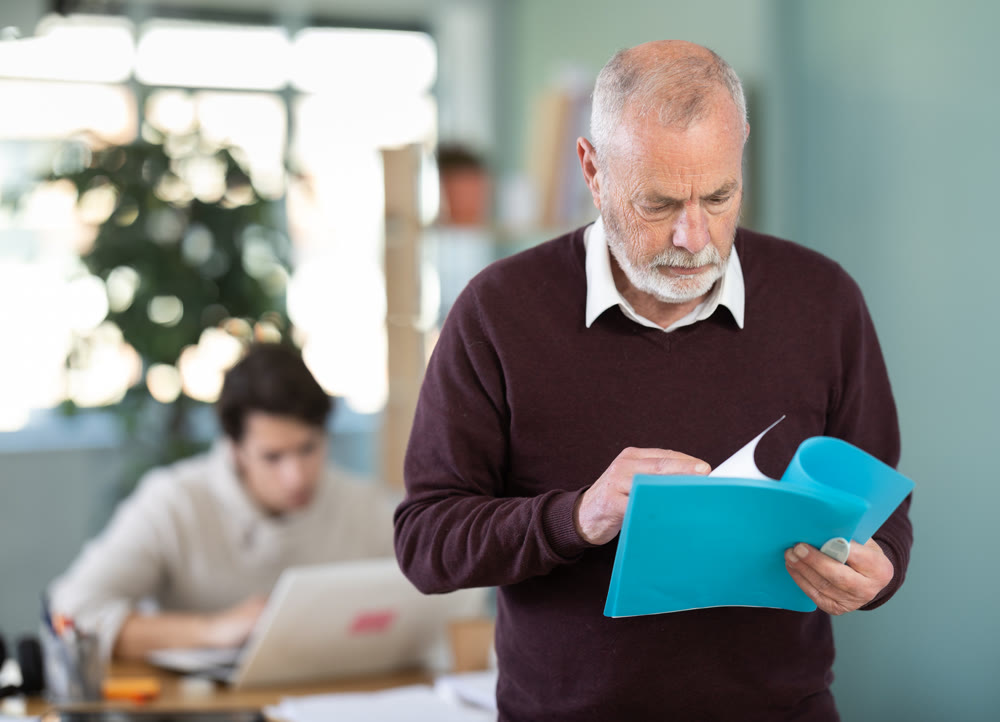 Senior man office male employee read documents