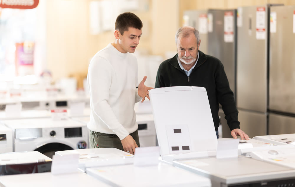 Men of different ages choose a dishwasher and a washing machine