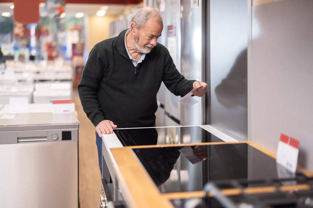 Elderly man chooses stove in appliance store