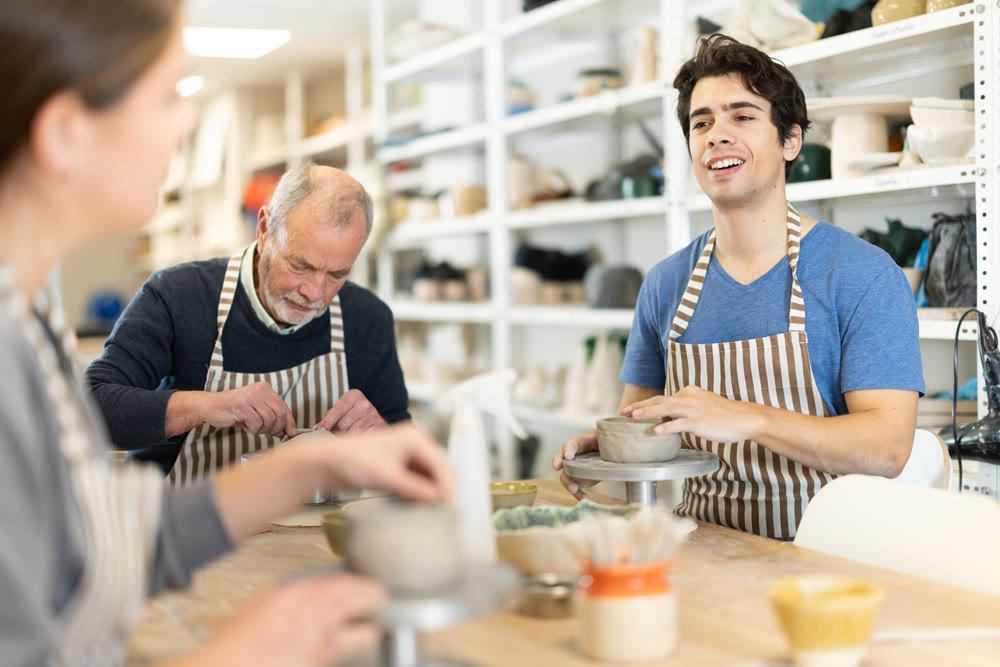 Young woman and man and elderly man crafting ceramics