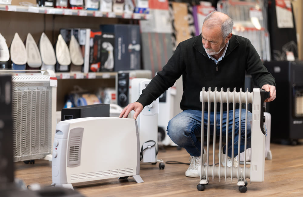 Mature man choose oil heater at supermarket