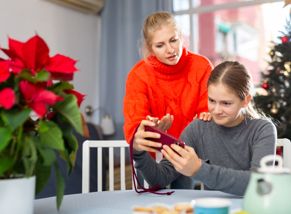 Girl sitting with phone and ignoring her mother