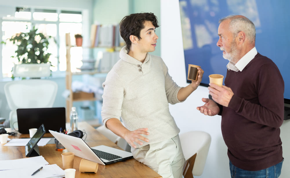 Male colleagues drink coffee and have nice conversation during break