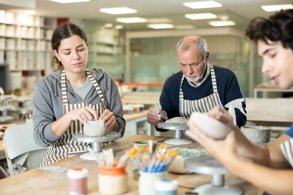 Young woman and man and elderly man crafting ceramics