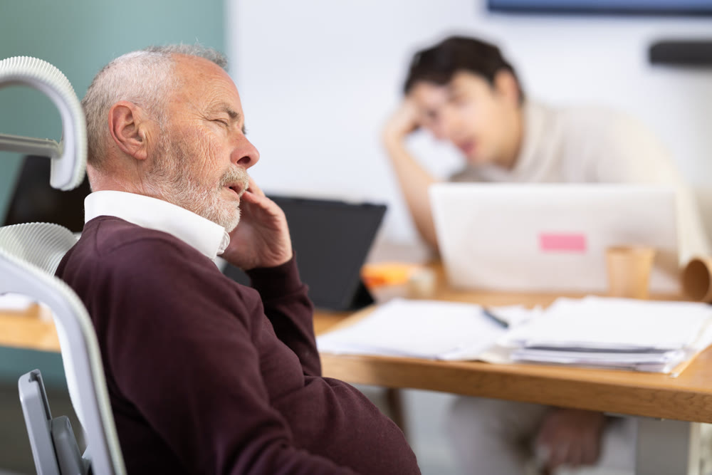 Tired male office workers having nap while sitting in workplace