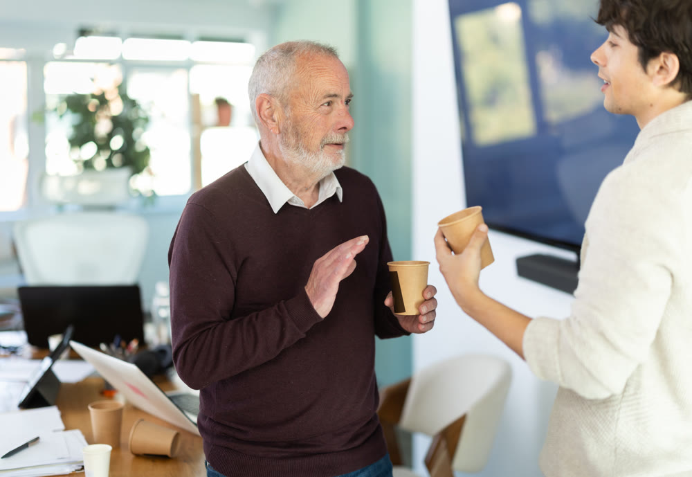 Male colleagues drink coffee and have nice conversation during break