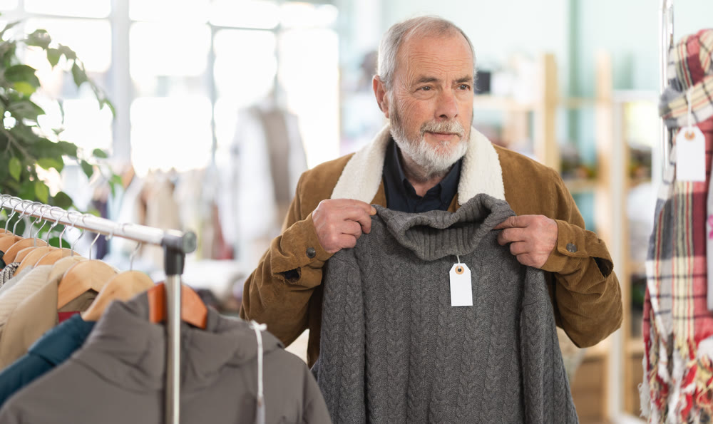 Family clothing store, senior man customer choose winter sweater