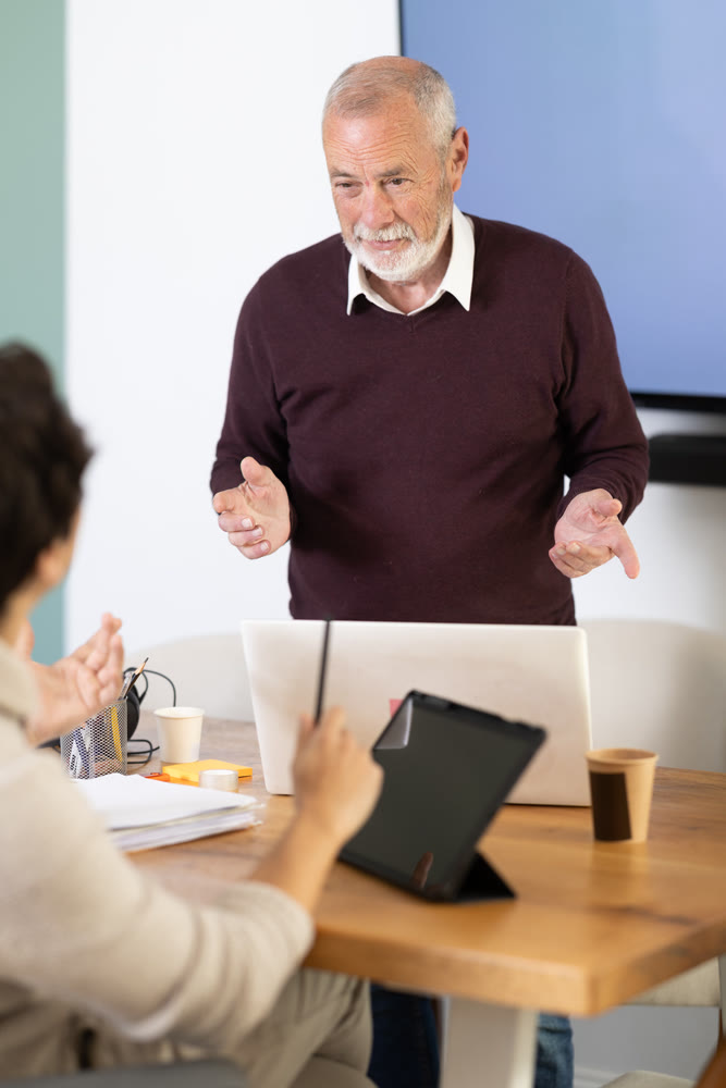 Two managers discuss work projects in company office