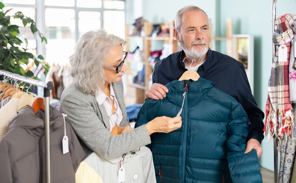Elderly couple choosing a warm down jacket together