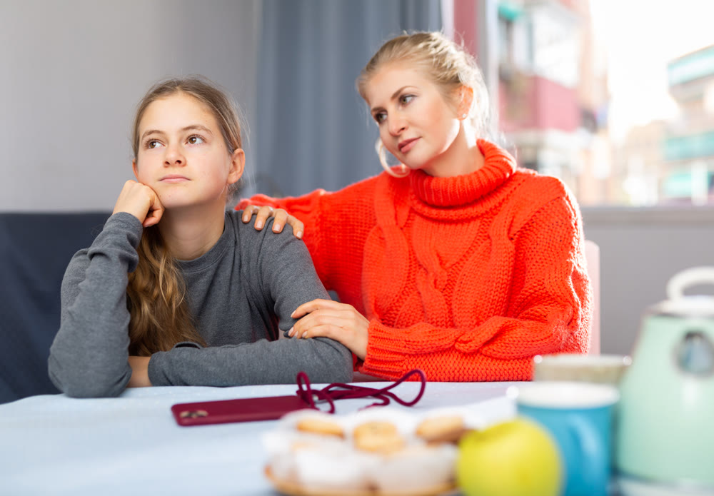 Portrait of woman trying to talk with daughter in home