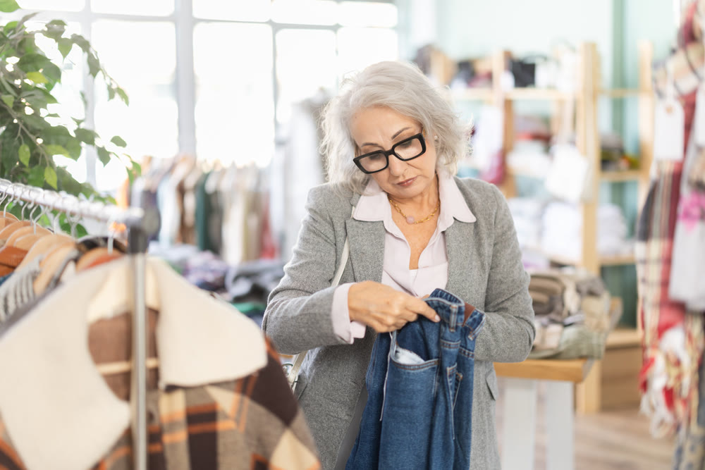 Mature woman standing in store and choosing jeans