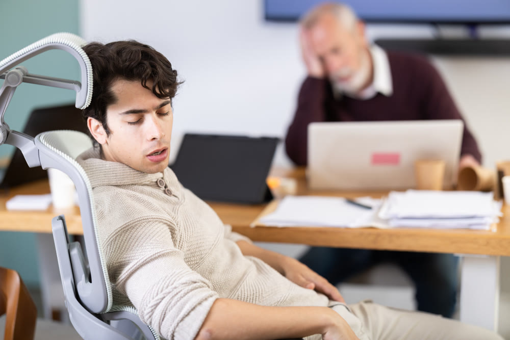 Tired elderly and young male colleagues fall asleep while working