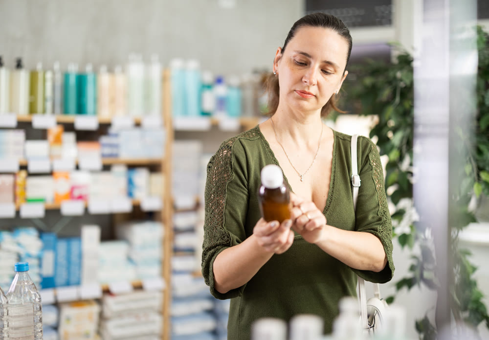 Woman are busy choosing antitussive suryp at pharmacy