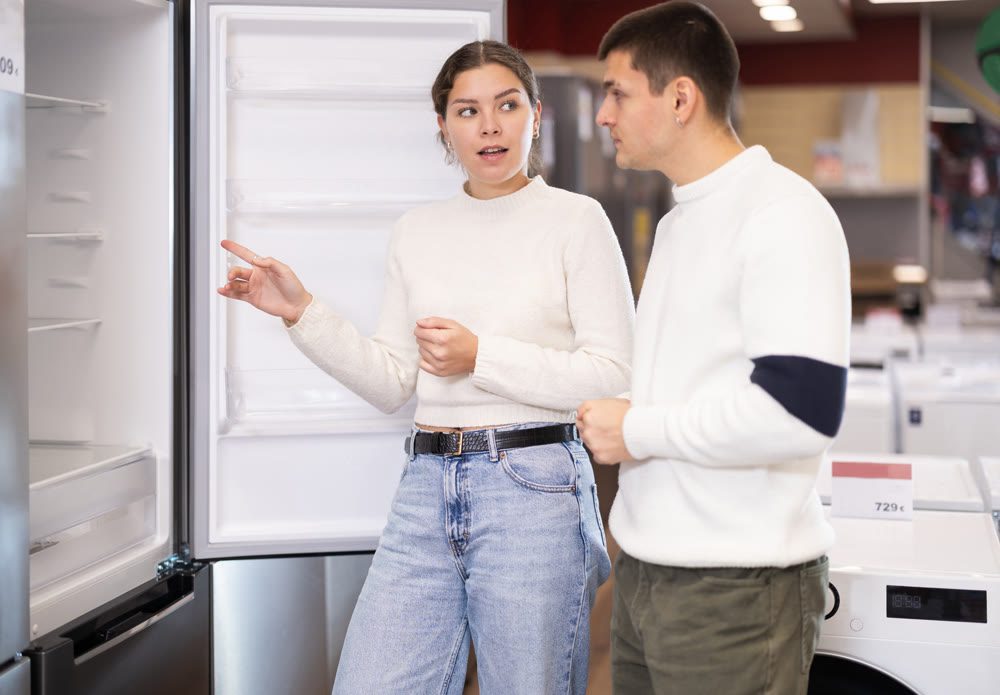 Couple choosing a refrigerator in an equipment store