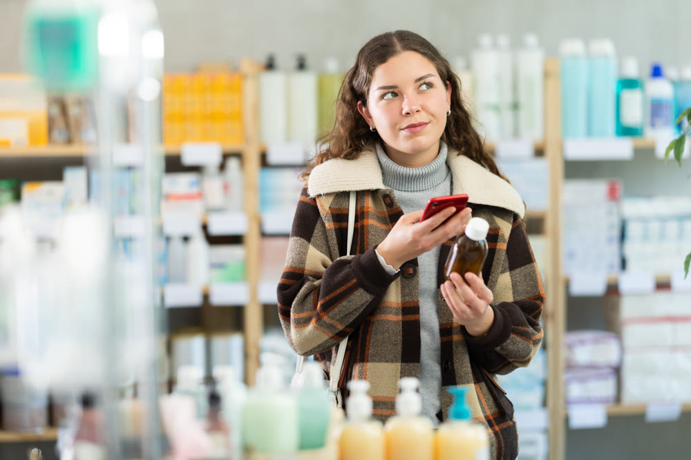 Young woman scanning qr code of syrup