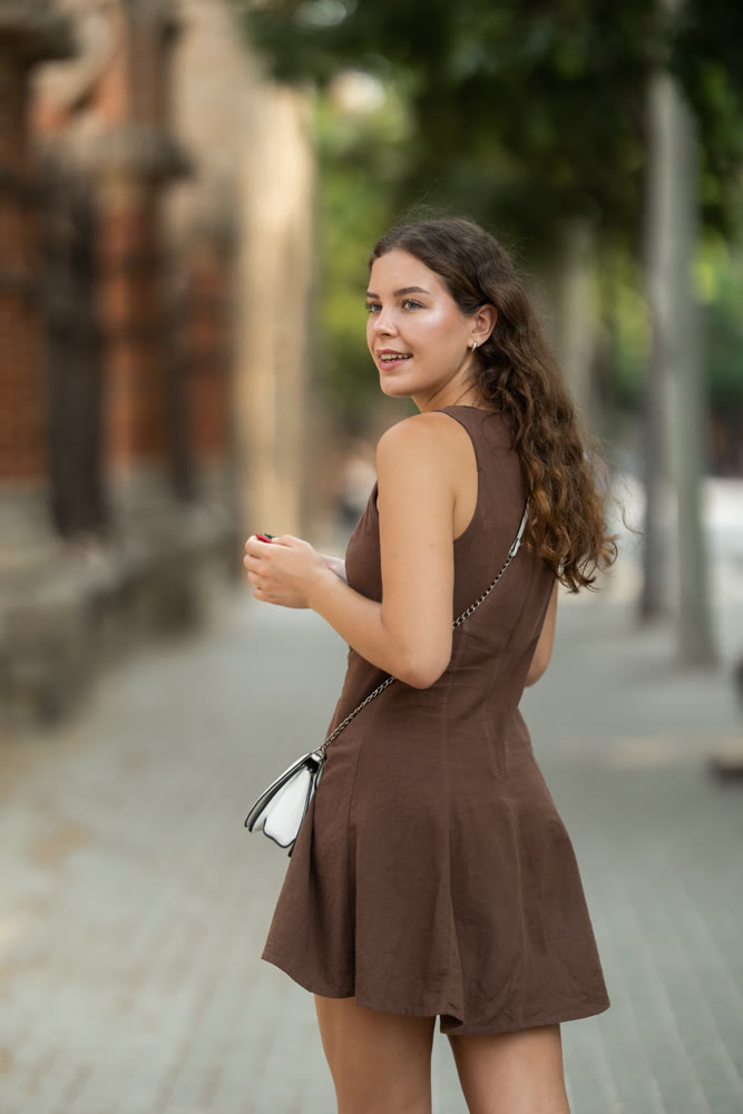 woman stands on the street with a phone in her hands and turns around