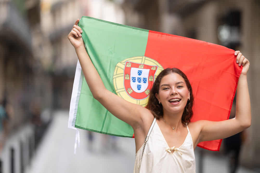 Young woman with Portuguese flag on city street