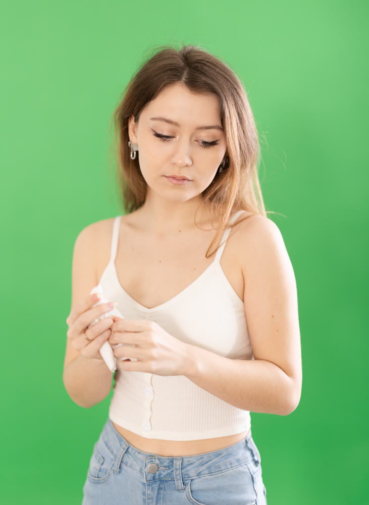 Sad young woman in casual clothes standing on chromakey background