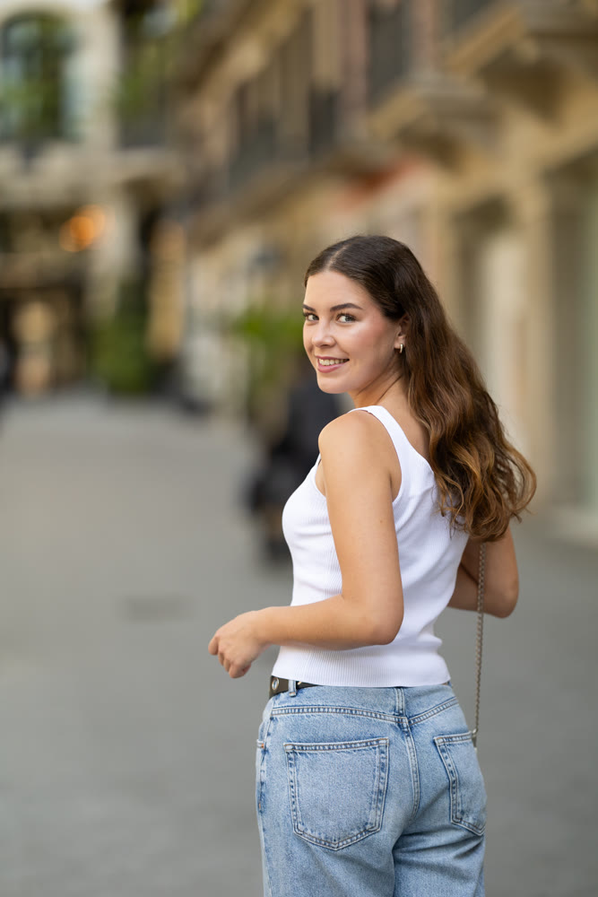 Girl turning with calm relaxed expression on sunny street
