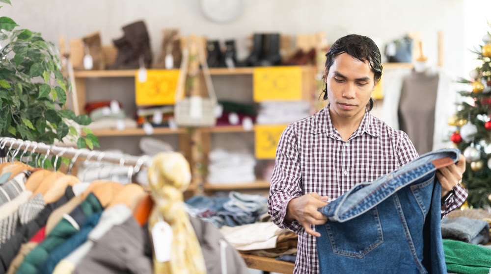 In chain shop, Indonesian man choose jeans, X mas shopping
