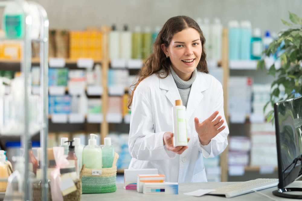 Positive female pharmacist offers to buy medicated hair shampoo