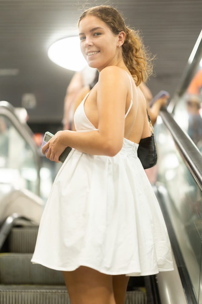 Young woman standing on escalator in subway