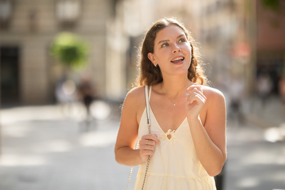 Young woman looks around on city street