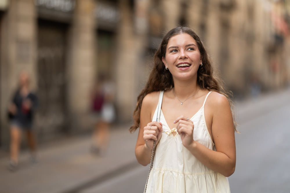 Young woman in white dress walking along the streets of the historical center of city