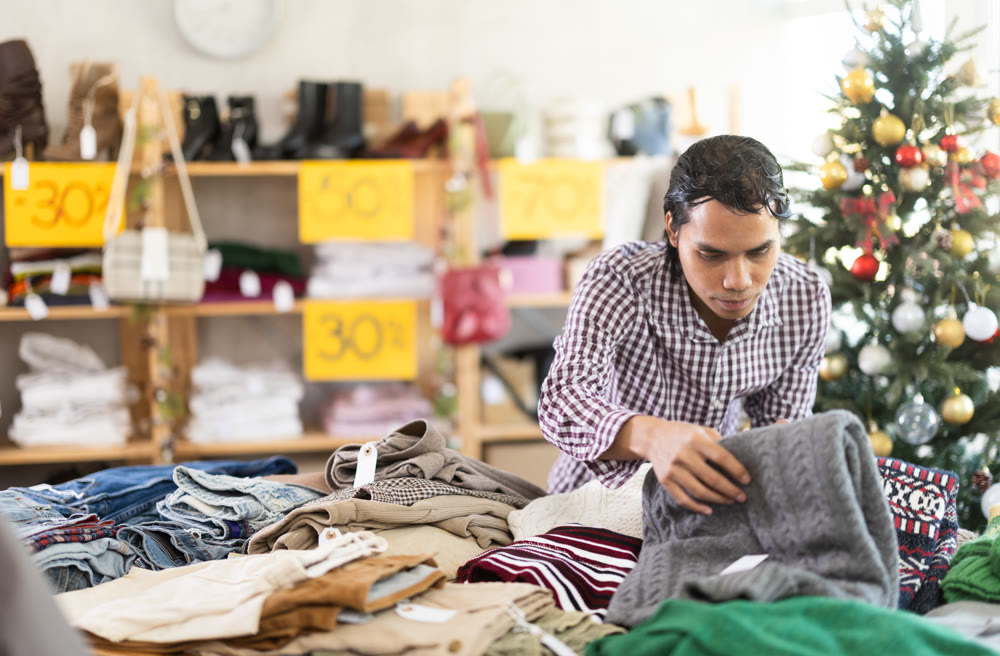 In chain shop, Indonesian man choose sweater, X mas shopping