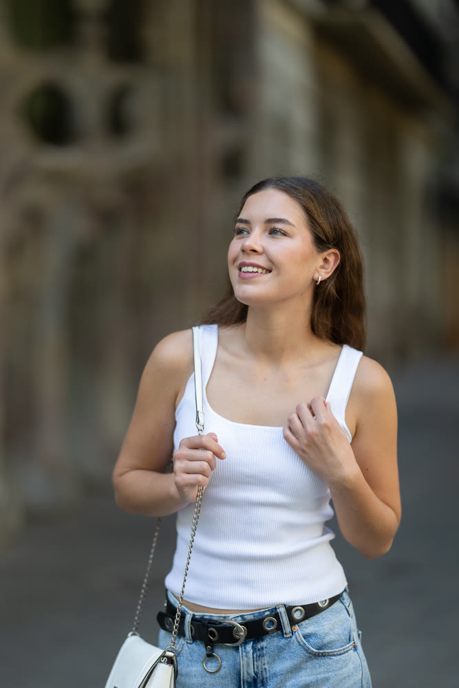 Young smiling girl walks along city street