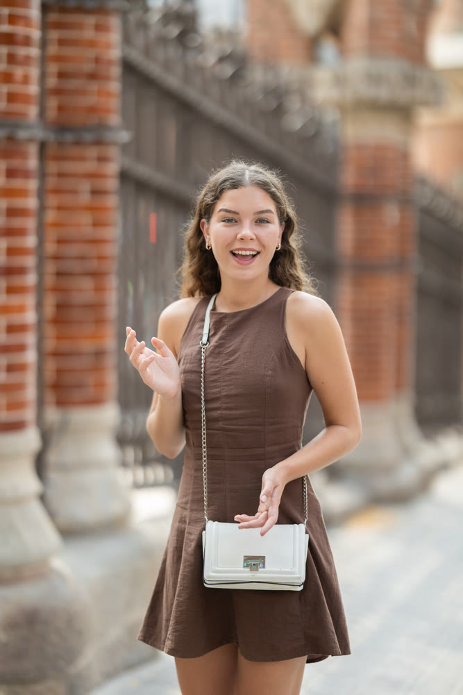 Young woman standing near the metal fence
