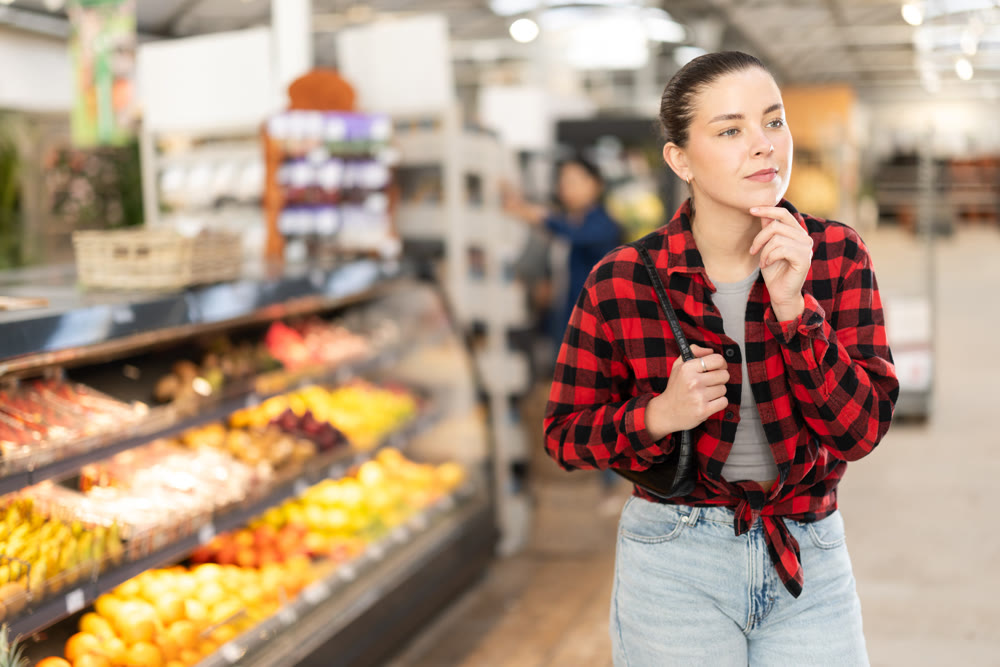 Young woman choosing food in grocery store