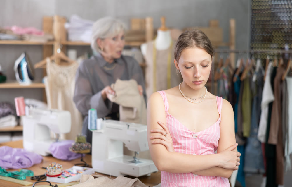 Mature dressmaker scolds assistant at work