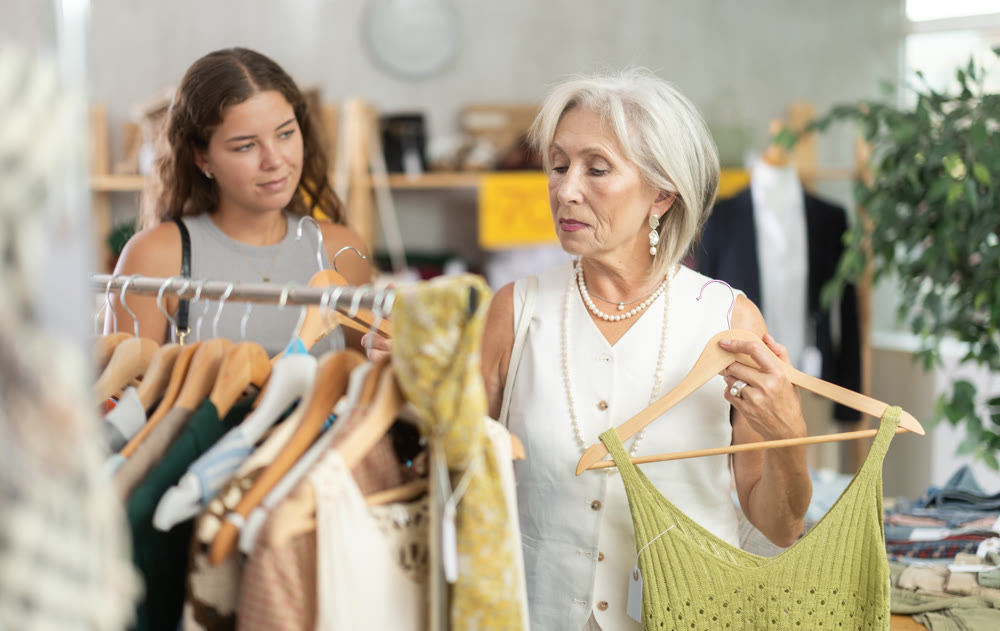 Elderly and young women choosing summer clothes in store