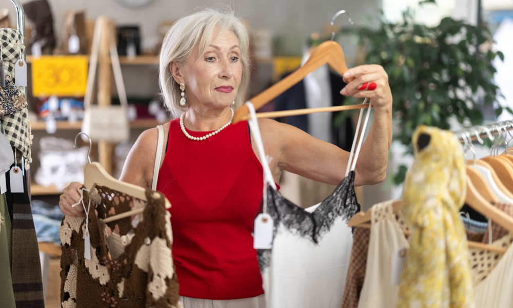 Elderly woman choosing summer clothes in store