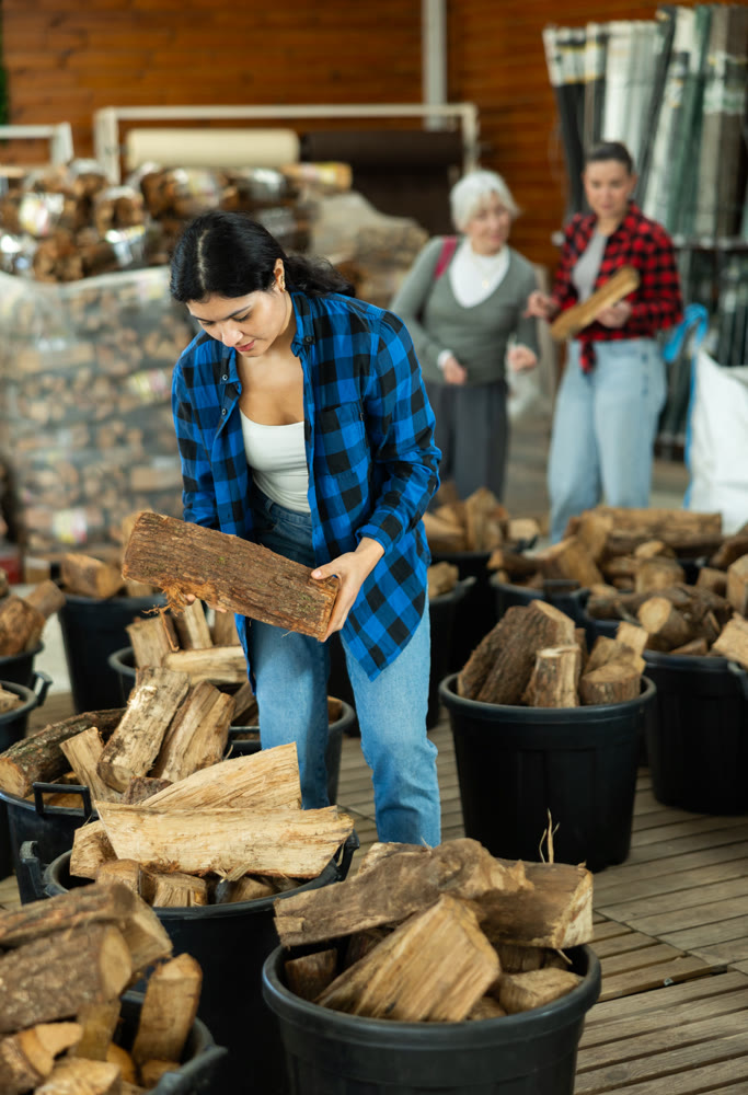 Young woman choosing firewood in store